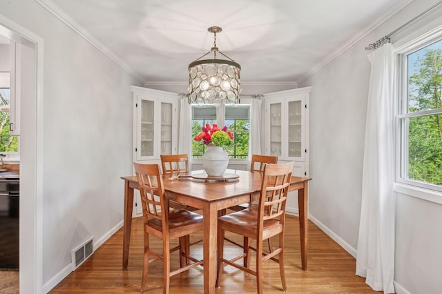 4428 Marlborough Ct, Minnetonka, MN 55345 - dining space with healthy amount of natural light, light wood finished floors, ornamental molding, and a chandelier