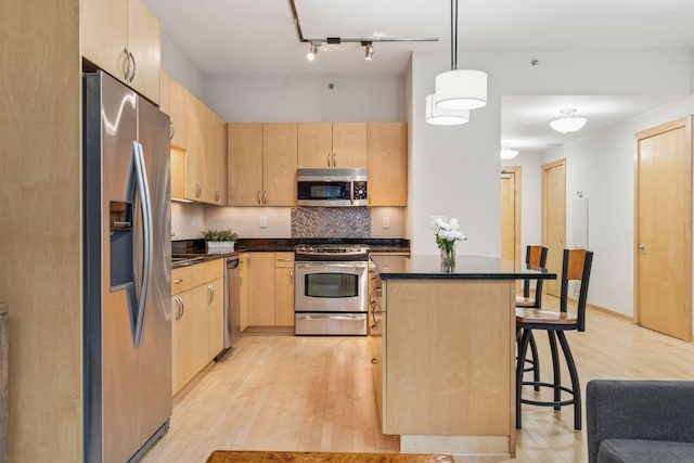 215 10th Ave S Unit 533, Minneapolis, MN 55415 - kitchen featuring stainless steel appliances, light brown cabinets, a breakfast bar, and dark countertops