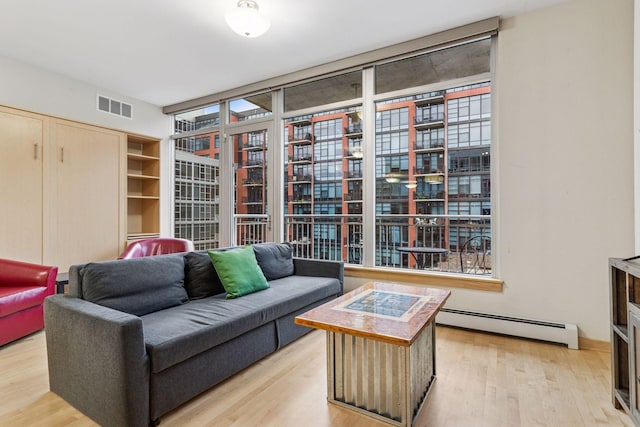 215 10th Ave S Unit 533, Minneapolis, MN 55415 - living area with a baseboard heating unit, light wood-style floors, and expansive windows
