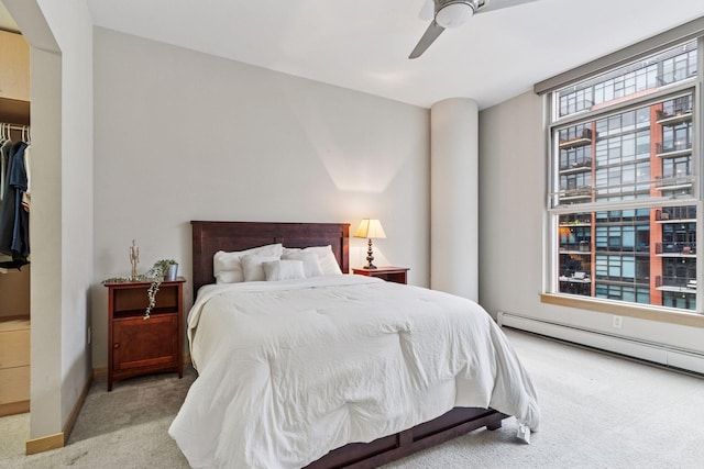 215 10th Ave S Unit 533, Minneapolis, MN 55415 - bedroom featuring carpet, baseboard heating, ceiling fan, and a walk in closet
