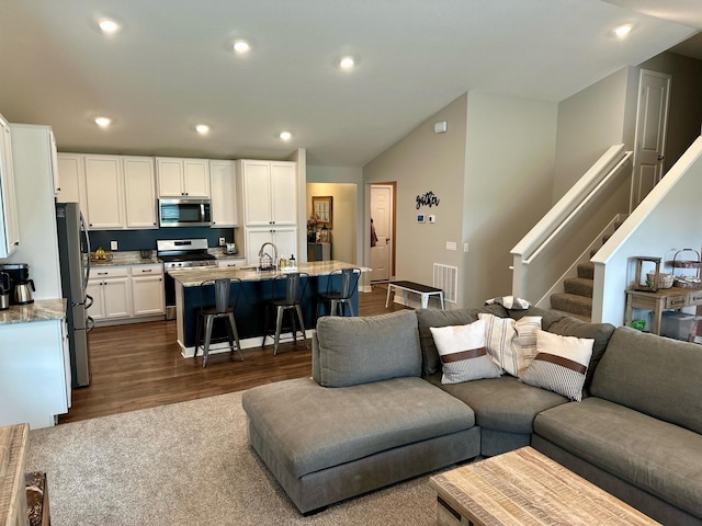 7559 Oday Ln NE, Otsego, MN 55330 - living area featuring vaulted ceiling, stairway, dark wood-type flooring, and recessed lighting