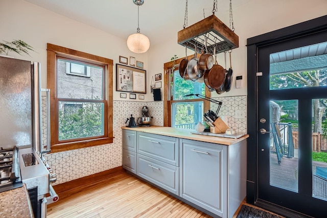 2707 Brighton Ave NE, Minneapolis, MN 55418 - kitchen featuring light wood-style flooring, plenty of natural light, gray cabinets, and tasteful backsplash