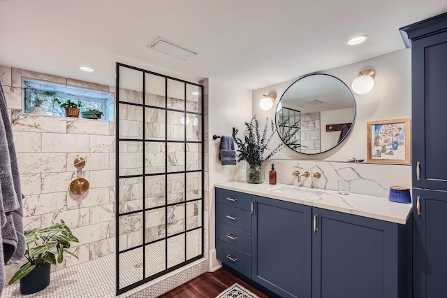 2707 Brighton Ave NE, Minneapolis, MN 55418 - bathroom featuring walk in shower, vanity, wood finished floors, and backsplash