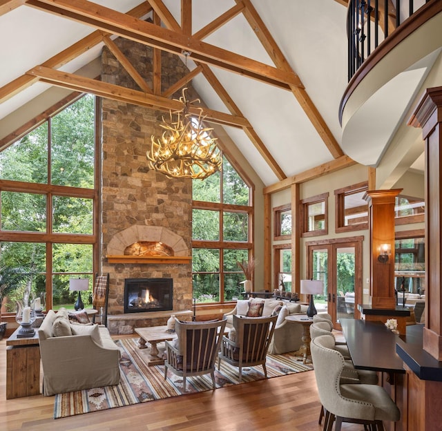 6445 County Road 26, Minnetrista, MN 55364 - living room featuring high vaulted ceiling, wood finished floors, a stone fireplace, a chandelier, and beam ceiling