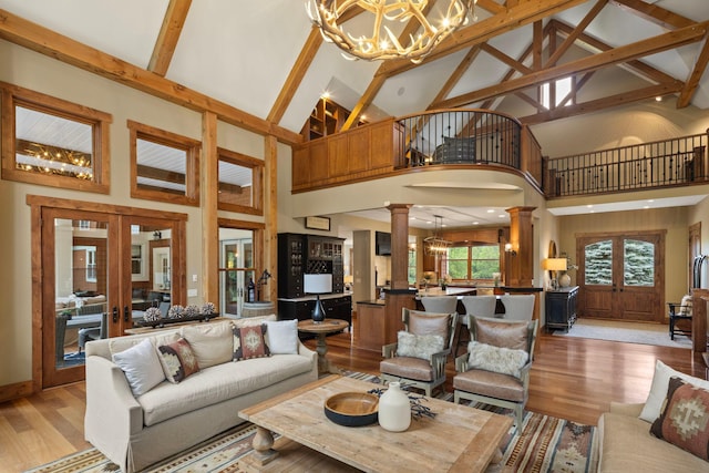 6445 County Road 26, Minnetrista, MN 55364 - living room with decorative columns, a chandelier, high vaulted ceiling, light wood finished floors, and beamed ceiling
