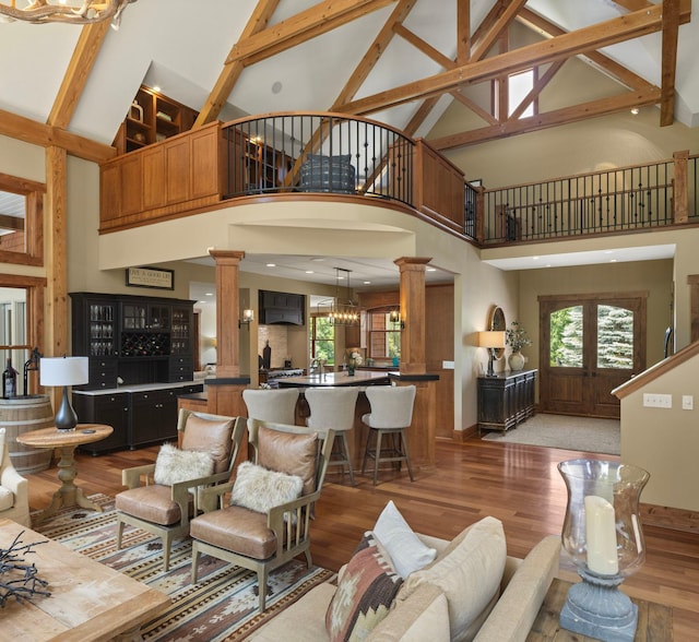 6445 County Road 26, Minnetrista, MN 55364 - living room featuring ornate columns, high vaulted ceiling, light wood-style floors, plenty of natural light, and beamed ceiling