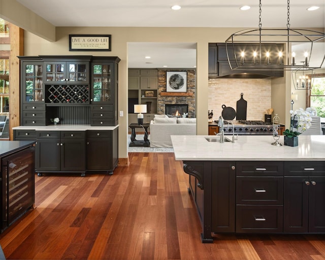 6445 County Road 26, Minnetrista, MN 55364 - kitchen with beverage cooler, exhaust hood, dark wood-style flooring, glass insert cabinets, and a chandelier