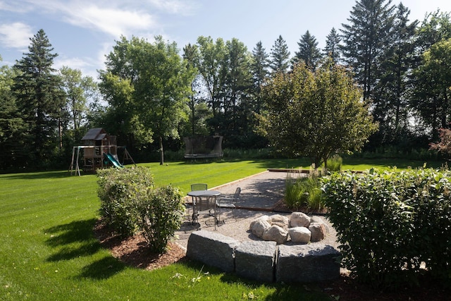 6445 County Road 26, Minnetrista, MN 55364 - view of grassy yard with a playground, a patio area, and a trampoline