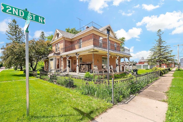 531 2nd St N, Brownton, MN 55312 - view of front facade featuring covered porch, brick siding, and a fenced front yard