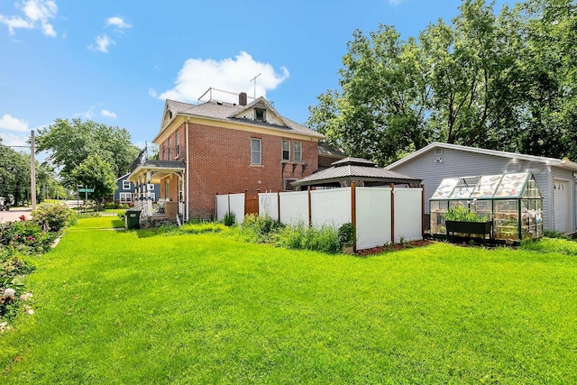 531 2nd St N, Brownton, MN 55312 - back of property with a greenhouse, brick siding, an outbuilding, and a gazebo