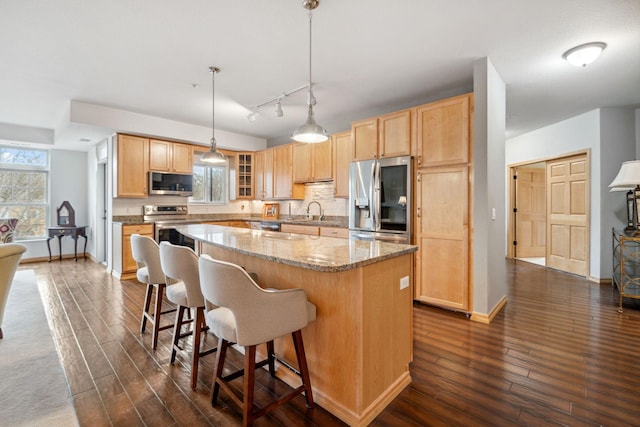 1700 Metro Blvd Unit 210, Edina, MN 55439 - kitchen with appliances with stainless steel finishes, light brown cabinetry, a kitchen island, and dark wood-style floors