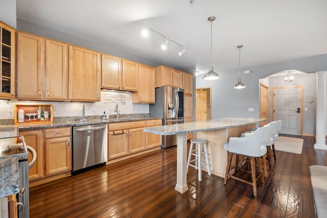 1700 Metro Blvd Unit 210, Edina, MN 55439 - kitchen featuring stainless steel appliances, light brown cabinetry, dark wood-type flooring, arched walkways, and a breakfast bar area
