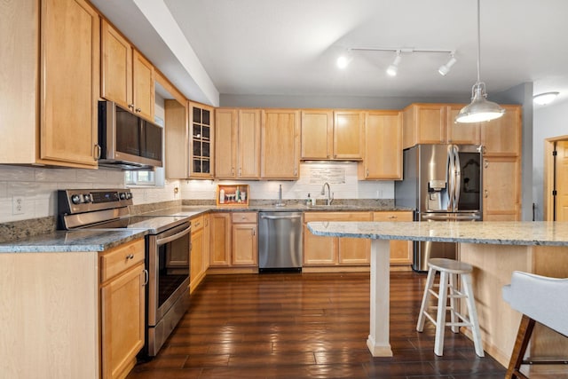 1700 Metro Blvd Unit 210, Edina, MN 55439 - kitchen with appliances with stainless steel finishes, a breakfast bar area, light brown cabinetry, glass insert cabinets, and light stone countertops