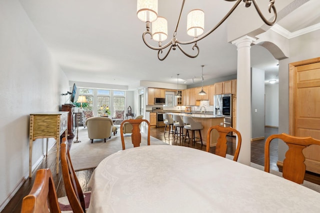 1700 Metro Blvd Unit 210, Edina, MN 55439 - dining area featuring decorative columns, dark wood finished floors, crown molding, and a chandelier