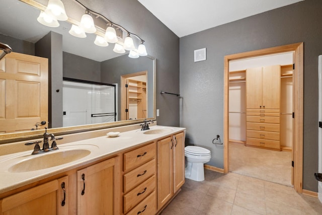 1700 Metro Blvd Unit 210, Edina, MN 55439 - bathroom with a shower stall, double vanity, tile patterned flooring, a spacious closet, and a textured wall