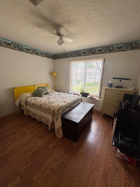 9257 Prairieview Trl N, Champlin, MN 55316 - bedroom with wood finished floors, a textured ceiling, and a ceiling fan