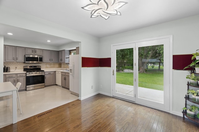 4990 148th Path W, Apple Valley, MN 55124 - kitchen featuring stainless steel appliances, gray cabinetry, decorative backsplash, light countertops, and a chandelier
