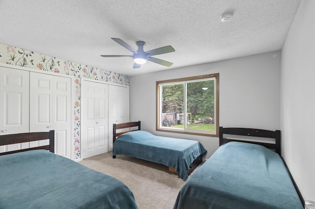 4990 148th Path W, Apple Valley, MN 55124 - carpeted bedroom featuring two closets, a textured ceiling, a ceiling fan, and wallpapered walls