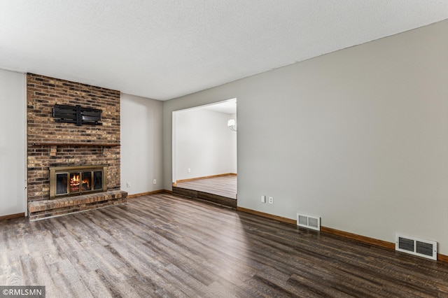 7216 Vinewood Ln N, Maple Grove, MN 55311 - unfurnished living room with wood finished floors, a textured ceiling, and a brick fireplace
