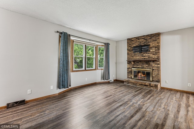 7216 Vinewood Ln N, Maple Grove, MN 55311 - unfurnished living room featuring wood finished floors, a brick fireplace, and a textured ceiling