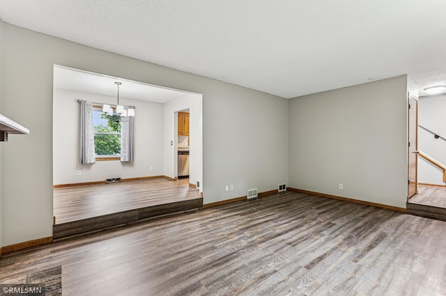 7216 Vinewood Ln N, Maple Grove, MN 55311 - spare room featuring wood finished floors and a chandelier