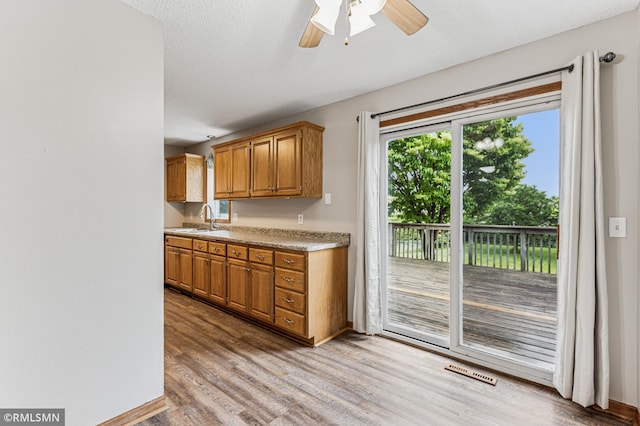 7216 Vinewood Ln N, Maple Grove, MN 55311 - kitchen featuring light wood-style floors, ceiling fan, light countertops, and brown cabinets