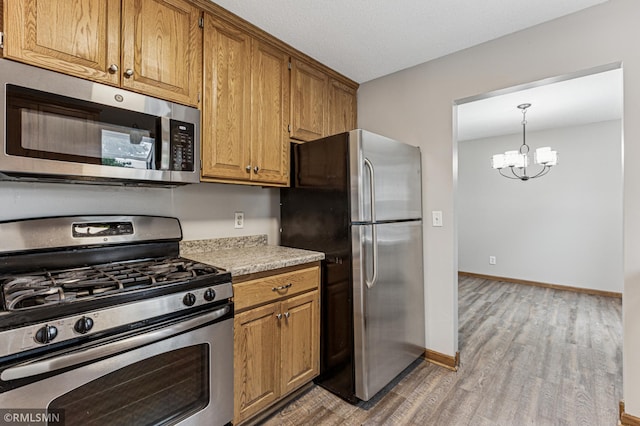 7216 Vinewood Ln N, Maple Grove, MN 55311 - kitchen with appliances with stainless steel finishes, light wood-type flooring, a chandelier, light countertops, and brown cabinets