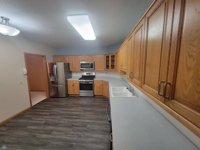 2501 30th Ave S Unit 109, Fargo, ND 58103 - kitchen featuring stainless steel appliances, dark wood-style floors, light countertops, glass insert cabinets, and a textured ceiling