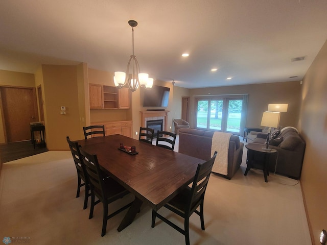 2501 30th Ave S Unit 109, Fargo, ND 58103 - dining area with a tile fireplace, a chandelier, recessed lighting, and light colored carpet