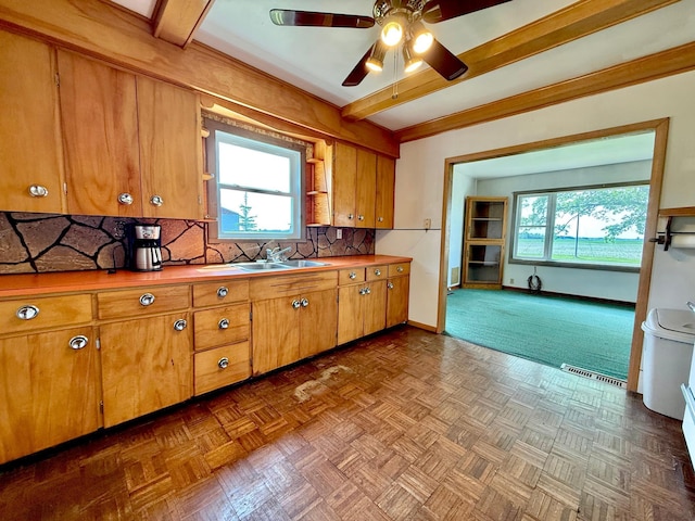 12900 350th Ave SE, Deer Park Twp, MN 56684 - kitchen with ceiling fan, decorative backsplash, brown cabinets, and beam ceiling