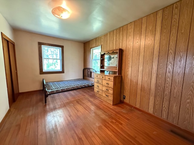 12900 350th Ave SE, Deer Park Twp, MN 56684 - bedroom featuring light wood-type flooring and wood walls