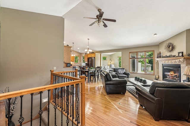 1364 Island View Dr, New Richmond, WI 54017 - living area featuring a ceiling fan, a glass covered fireplace, light wood finished floors, a chandelier, and recessed lighting