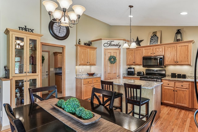 1364 Island View Dr, New Richmond, WI 54017 - kitchen featuring stainless steel range with gas stovetop, a kitchen island, a chandelier, light wood-type flooring, and high vaulted ceiling