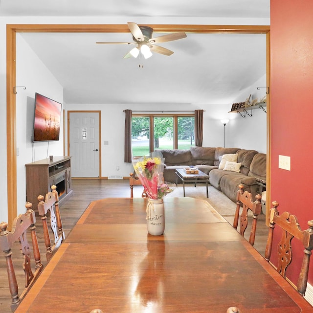 112 3rd St, Luck, WI 54853 - dining space featuring a ceiling fan, a warm lit fireplace, and light wood finished floors