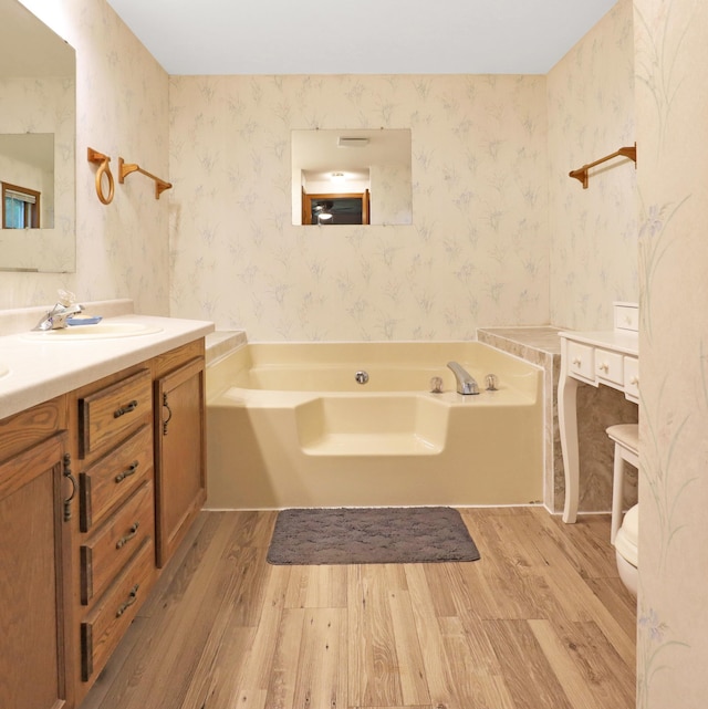 112 3rd St, Luck, WI 54853 - full bathroom with wood finished floors, vanity, a bath, and wallpapered walls