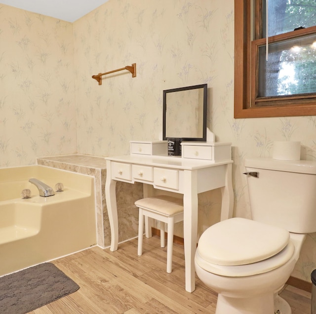 112 3rd St, Luck, WI 54853 - bathroom with wood finished floors, a bath, and wallpapered walls