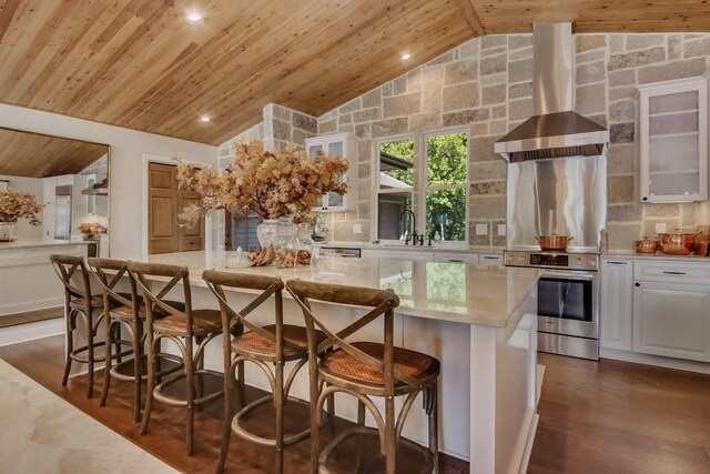 7 3rd St, Pepin, WI 54759 - kitchen featuring wood ceiling, stainless steel range, wall chimney range hood, white cabinets, and a center island