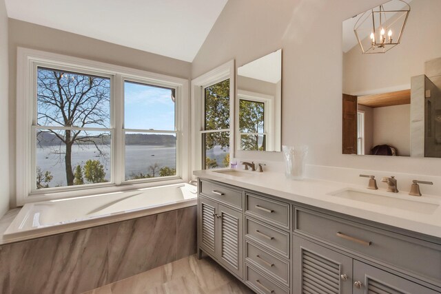 7 3rd St, Pepin, WI 54759 - full bathroom featuring plenty of natural light, lofted ceiling, double vanity, a garden tub, and a chandelier