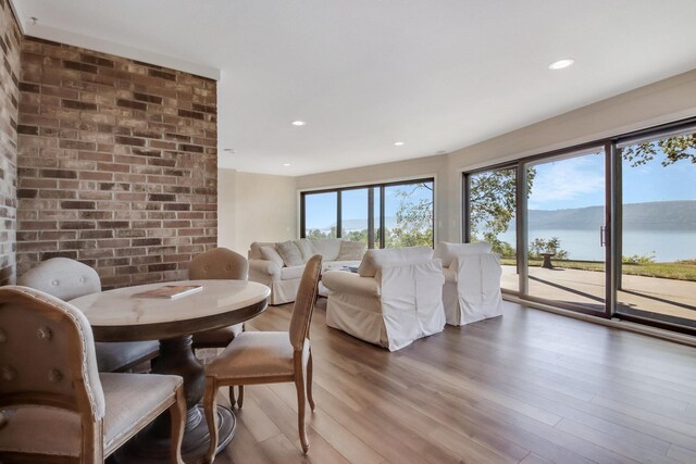 7 3rd St, Pepin, WI 54759 - dining area with light wood-type flooring, a water view, recessed lighting, and brick wall