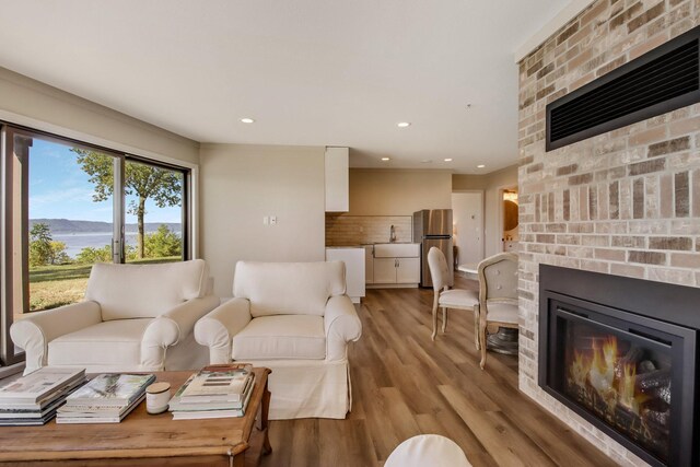 7 3rd St, Pepin, WI 54759 - living room featuring a brick fireplace, light wood-type flooring, recessed lighting, and a water view