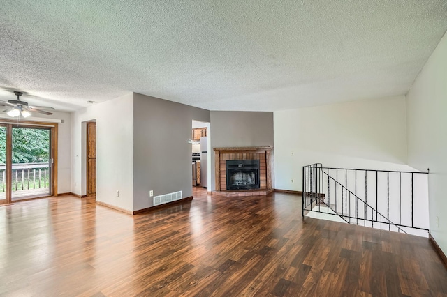 2833 Flag Ave N, New Hope, MN 55427 - unfurnished living room featuring wood finished floors, a textured ceiling, a ceiling fan, and a brick fireplace