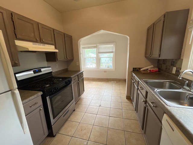 3306 Humboldt Ave N, Minneapolis, MN 55412 - kitchen featuring white appliances, under cabinet range hood, light tile patterned floors, dark countertops, and tasteful backsplash