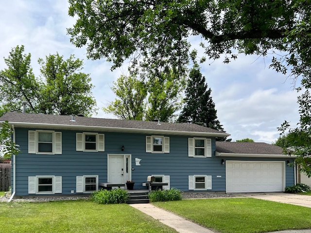 907 22nd Ave S, Moorhead, MN 56560 - bi-level home with driveway, an attached garage, and a front lawn