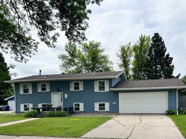 907 22nd Ave S, Moorhead, MN 56560 - raised ranch featuring driveway, an attached garage, and a front yard