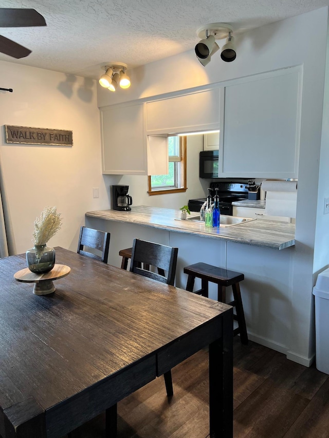 907 22nd Ave S, Moorhead, MN 56560 - dining area featuring dark wood-type flooring and a textured ceiling