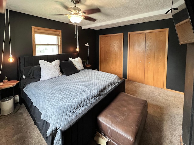 907 22nd Ave S, Moorhead, MN 56560 - carpeted bedroom featuring multiple closets, a ceiling fan, and a textured ceiling