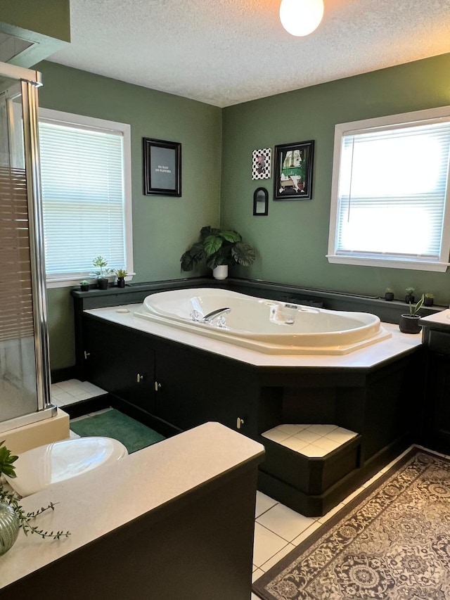 907 22nd Ave S, Moorhead, MN 56560 - bathroom featuring a textured ceiling, a bath, a shower stall, and tile patterned floors