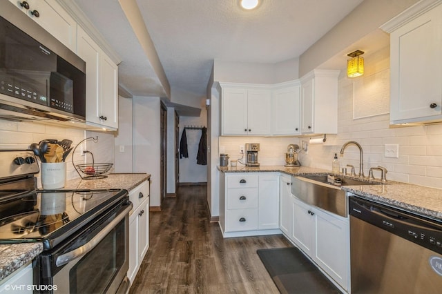 1007 124th Cir NW, Coon Rapids, MN 55448 - kitchen with stainless steel appliances, tasteful backsplash, white cabinetry, and dark wood finished floors