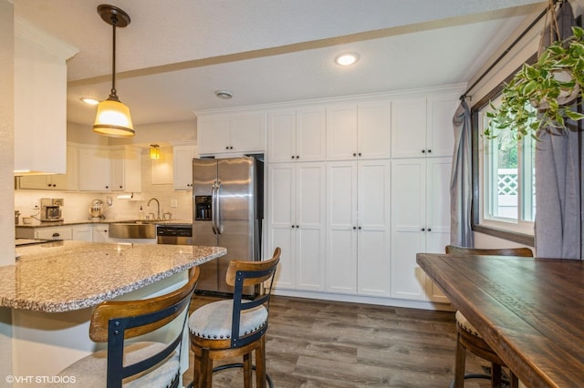 1007 124th Cir NW, Coon Rapids, MN 55448 - kitchen featuring appliances with stainless steel finishes, dark wood-style flooring, light stone counters, white cabinetry, and recessed lighting