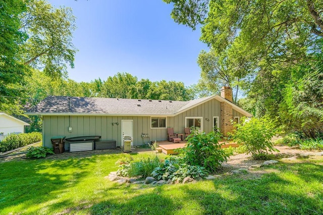 1755 Ranier Ln N, Plymouth, MN 55447 - back of property featuring a deck, a yard, a chimney, a shingled roof, and board and batten siding